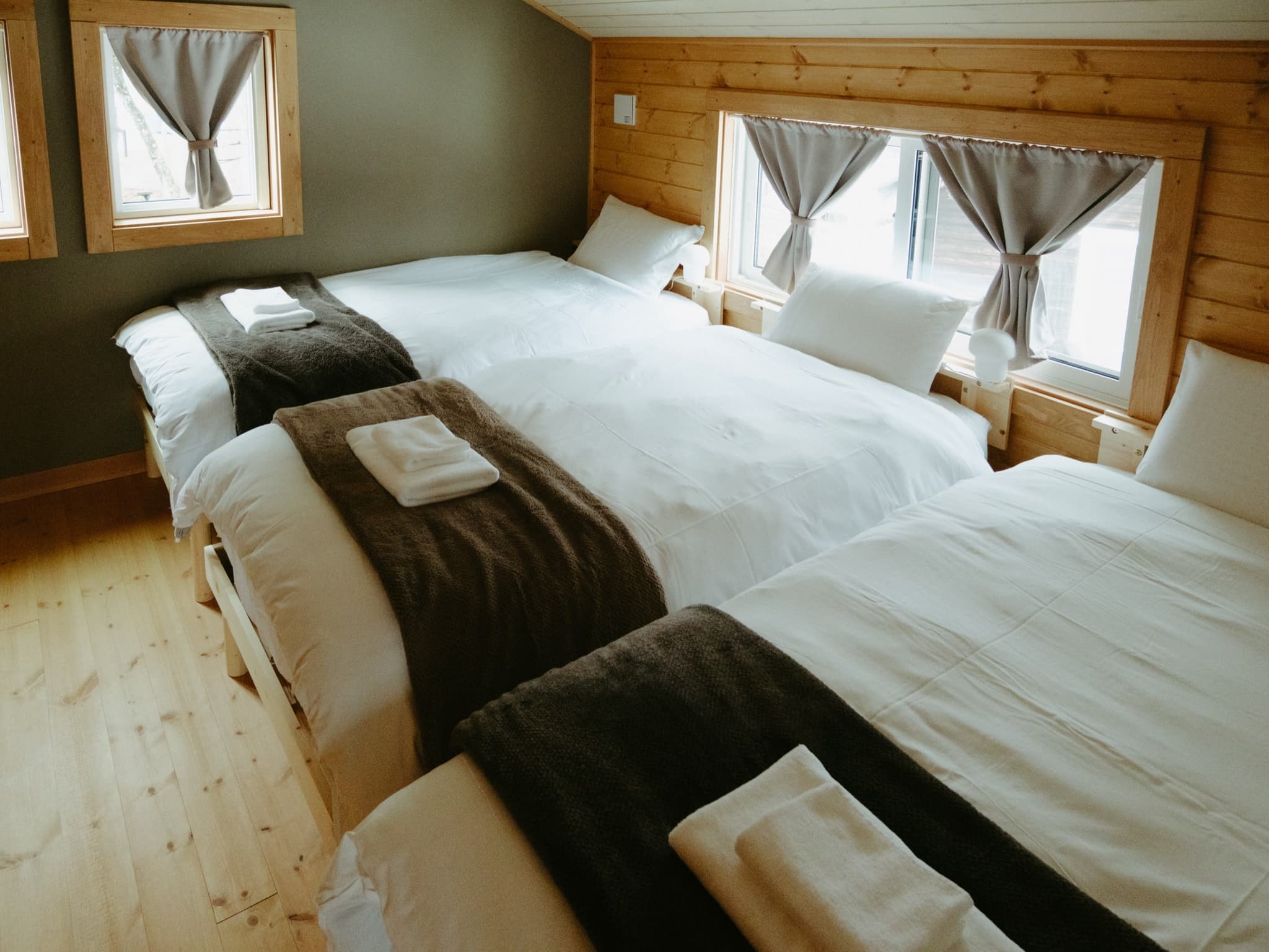 Triple Western Room — A calm western-style room with warm wooden finishes, suited for up to three guests.